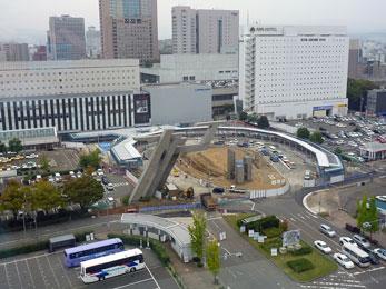 平成23年10月の工事進捗、北西から撮影した写真。バスロータリーに出来た白い屋根のシェルターが見えている。