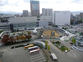 平成23年11月の工事進捗、北西から撮影した写真。ロータリー内部が整地され車が数台通行している。