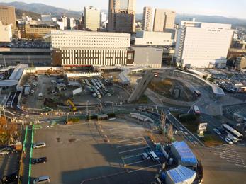 平成24年12月の工事進捗、北西から撮影した写真。手前の駐車場とタクシー乗降場の間の道路にクレーン車が入り工事をしている。