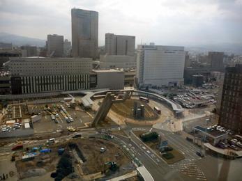 平成25年3月の工事進捗、北西から撮影した写真。手前の駐車場では土を盛り返し工事が行われている。
