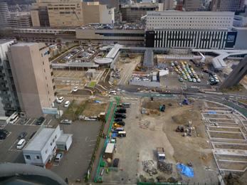 平成25年4月の工事進捗、北西から撮影した写真。手前の駐車場の右側にアスファルトの枠が数個作られている。