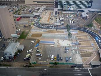 平成25年7月の工事進捗、北西から撮影した写真。手前の駐車場の地面に青い線が数本塗られている。