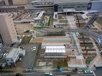 平成26年3月の工事進捗、北西から撮影した写真。手前の駐車場が広場になり、周りに芝生が植えられている。