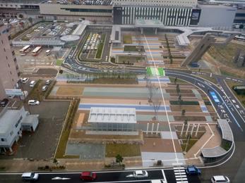 平成26年4月の工事進捗、北西から撮影した写真。手前に広岡1丁目広場、奥に整備されたタクシー乗降場や観光バス乗降場が写っている。