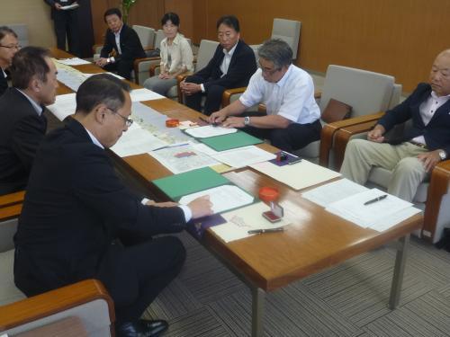 左手前側に座っている市長が書類に判を押している写真