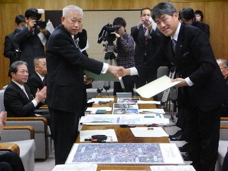 山出金沢市長と関係者の男性が握手をしている写真