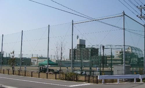 フェンスで囲まれた広場で野球が行われている米泉運動公園の写真