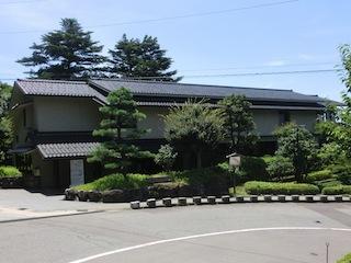 手前に庭園があり、奥に瓦のある日本屋敷が建っている卯辰山工芸工房の外観写真
