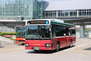 赤色の車体の城下まち金沢周遊バスが道路を走っている写真