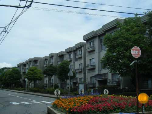 道路沿いに建つコンクリート作りの3階建て円光寺住宅外観写真