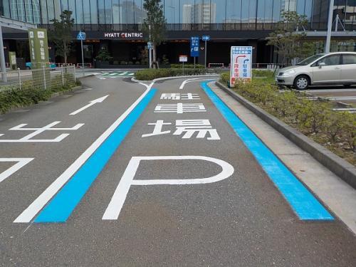 右側に曲がる道路に駐車場P、そして左右に青い線がひかれ、左側に曲がる道路に出口と書かれている写真