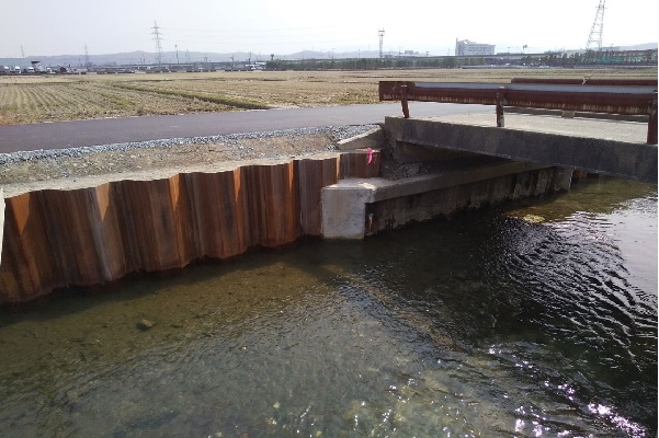 護岸改修工事が完了した様子。川岸が鋼矢板で補強されている。