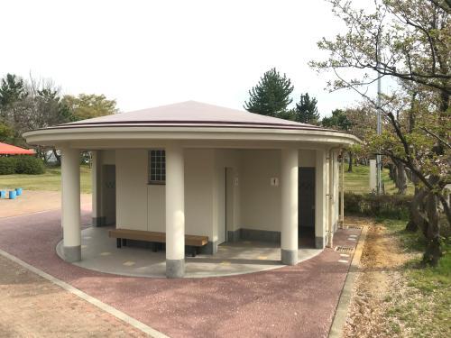 トイレ入り口前に円柱の柱が3本ある新保本町中央公園便所の外観写真