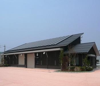 太陽光パネルがある茶色の外壁をした大桑防災備蓄倉庫の外観の写真