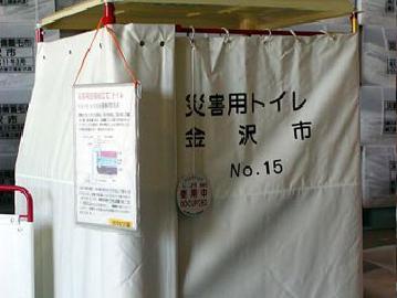 四角く布で囲われ、「災害用トイレ金沢市」と布に書かれている災害用トイレの写真