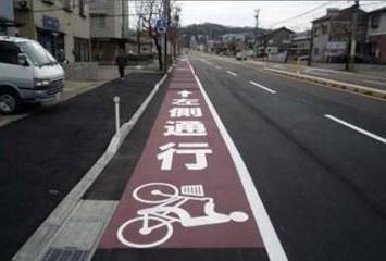 左側通行と道路に書かれた自転車レーンの写真