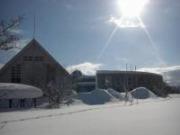 除雪した雪が建物がある道路側に積みあがっている様子を撮影した写真