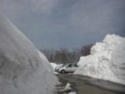 道の脇に3メートル高い積雪が残っている2月中旬の様子の写真