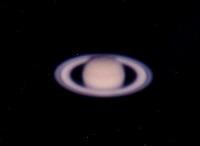 夜空に昇る少しぼんやりと映る土星の表面を撮影した写真