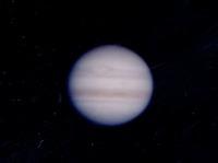 夜空に昇る少しぼんやりと映る木星の表面を撮影した写真