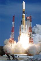 白い煙を上げながら発射台から打ち上げられる黄色いロケットの写真