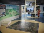2階の展示ホールを撮影した写真。床には大きな地図が、奥にはモニターがある。