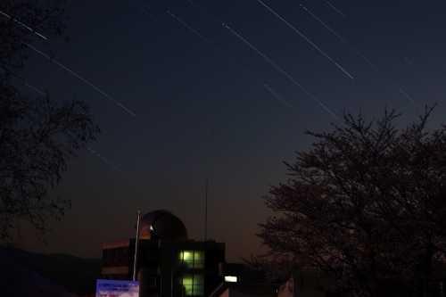 キゴ山施設の頭上の夜空に線を引く流れ星の写真